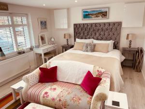 a bedroom with a large bed and a couch at Jayslin in Felpham