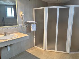 a bathroom with a shower and a sink at Hostal La Isla in Montijo +22 photos