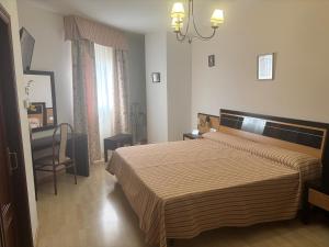 a bedroom with a bed and a chair in it at Hostal La Isla in Montijo