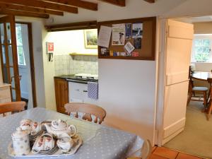a kitchen with a table with a tea set on it at Condurrow Cottage in Saint Anthony