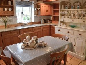 a kitchen with a table with a polka dot table cloth at Condurrow Cottage in Saint Anthony