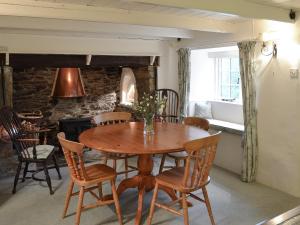 a dining room with a wooden table and chairs at Condurrow Cottage in Saint Anthony