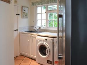 a kitchen with a washing machine and a sink at Condurrow Cottage in Saint Anthony +17 photos