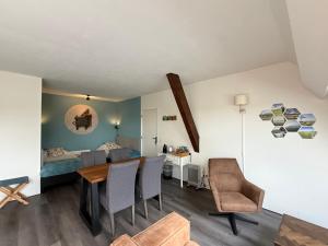a living room with a table and chairs and a bed at Bed and Breakfast de Salix in Hitzum