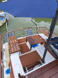 a deck of a boat with benches and an umbrella at Bleu soleil in Dieupentale
