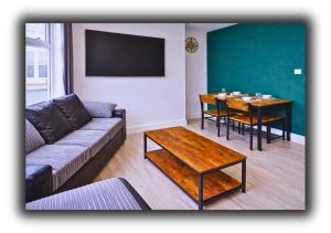 a living room with a couch and a table at Pitchside House Walk to Anfield sleeps 7 in Liverpool