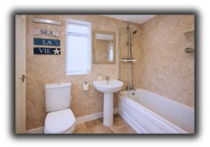 a bathroom with a toilet and a sink and a tub at Pitchside House Walk to Anfield sleeps 7 in Liverpool