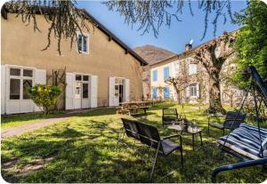 a yard with chairs and a table in front of a building at Villa Marisa in Ax-les-Thermes