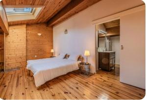 a bedroom with a large bed in a room with wooden floors at Villa Marisa in Ax-les-Thermes