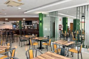 a restaurant with wooden tables and chairs and green walls at Hostal La Isla in Montijo