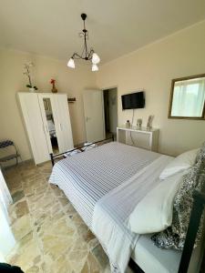 a bedroom with a large bed and a tv at Sotto i Monti House in Nicolosi