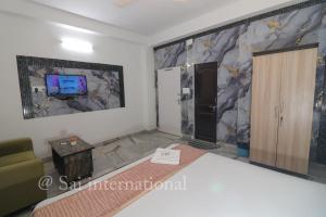 a living room with a couch and a tv at Sai International Guest House in kolkata