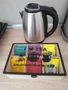a tray with a tea pot and a bunch of books at Luna apartman in Čačak