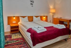 a bedroom with a large bed with towels on it at Muskatli Villa in Sovata