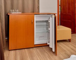 an empty refrigerator with its door open in a kitchen at Muskatli Villa in Sovata