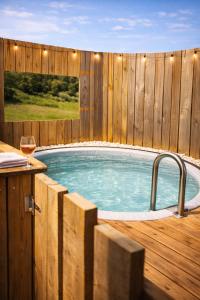a pool with a wooden fence and a hot tub at La bergerie des petits loups in Montagnac-la-Crempse