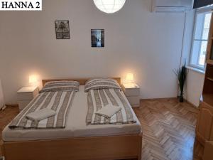 a bedroom with a large bed with two night stands at Hanna Apartman 1-2 in Kőszeg