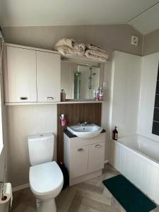 a bathroom with a toilet and a sink and a tub at haven kent coast in Allhallows +9 photos