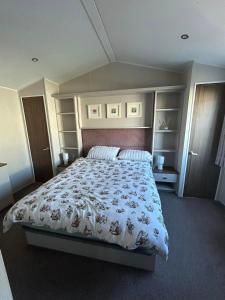 a bedroom with a large bed with a white comforter at haven kent coast in Allhallows