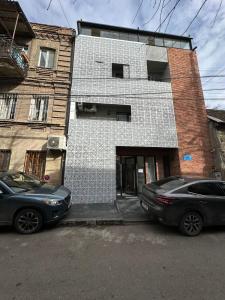 two cars parked in front of a building at Amber Boutique Hotel in Tbilisi City