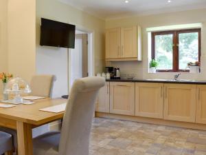 a kitchen with a wooden table and a dining room at The Oaks - Uk11270 in Lanreath