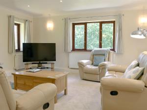a living room with couches and a flat screen tv at The Oaks - Uk11270 in Lanreath