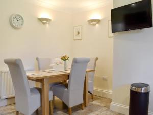 a dining room with a wooden table and chairs at The Oaks - Uk11270 in Lanreath