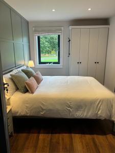a bedroom with a large white bed with a window at Lough View Lodge in Ballyronan +15 photos