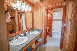 a bathroom with two sinks and a large mirror at Mike Wiegele Helicopter Skiing in Blue River +48 photos