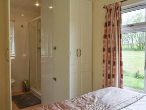 a bedroom with a shower and a bed and a window at The Lodge - Uk11271 in Lanreath +10 photos