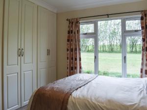 a bedroom with a bed and a large window at The Lodge - Uk11271 in Lanreath