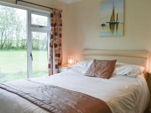 a bedroom with a large bed with a window at The Lodge - Uk11271 in Lanreath