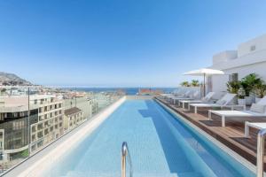 ein Swimmingpool auf dem Dach eines Gebäudes mit Blick auf das Meer in der Unterkunft Hotel Orquidea in Funchal