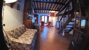 a living room with a couch and a staircase at THE ROOF HOUSE - appartamento piazza grande in Montepulciano