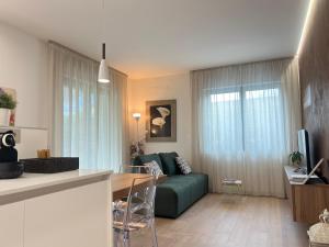 a living room with a green couch and a table at Agordo Suite in Agordo