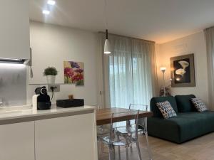 a kitchen and a living room with a green couch at Agordo Suite in Agordo