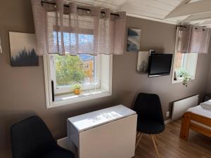 a room with two chairs and a desk and a window at Guest House Stare in Strömstad