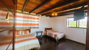 a bedroom with two beds and a window at Casa Bugambilia in Paso Hondo +61 photos