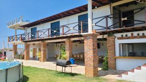 a house with a balcony and a swimming pool at Casa Bugambilia in Paso Hondo
