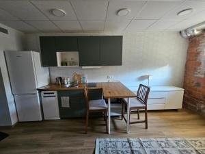 a kitchen with a table and chairs and a refrigerator at Arbimäe majutus tuba 24 in Elva