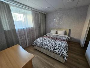 a bedroom with a bed with a black and white comforter at Arbimäe majutus tuba 24 in Elva