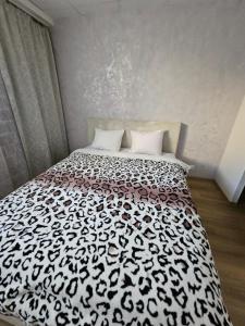 a bedroom with a bed with a black and white comforter at Arbimäe majutus tuba 24 in Elva