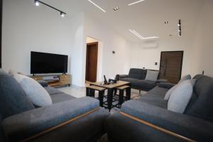 a living room with couches and a flat screen tv at دار المكارم للشقق الفندقية الفاخره in Jerash