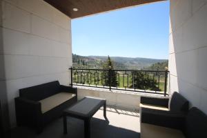 a balcony with a table and chairs and a view at دار المكارم للشقق الفندقية الفاخره in Jerash