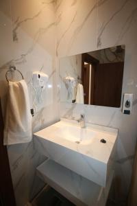 a bathroom with a white sink and a mirror at دار المكارم للشقق الفندقية الفاخره in Jerash