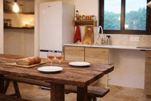 a wooden table with two glasses of wine and bread at La bergerie des petits loups in Montagnac-la-Crempse +6 photos