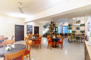 a restaurant with tables and chairs in a room at Shelton Rezidor House F-8 Islamabad in Islamabad