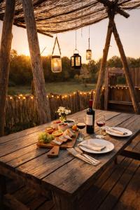 a wooden table with a plate of food and glasses of wine at La bergerie des petits loups in Montagnac-la-Crempse