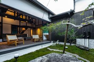 ein Haus mit einem Innenhof und einem Baum in der Unterkunft kyuuka in Nakatsu