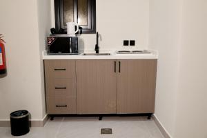 a kitchen with a sink and a microwave at رست للشقق المخدومة in Medina